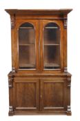A Victorian mahogany cabinet bookcase, circa 1880, inverted breakfront cornice, above a pair of