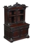 A William IV mahogany miniature cabinet bookcase, circa 1835, the shaped and scroll carved pediment