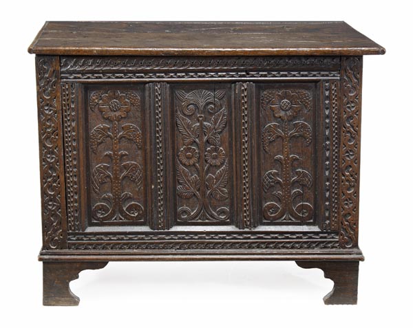 A panelled oak chest, 17th century and later, hinged top, above triple panelled front, carved with