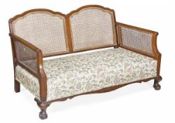 A walnut three piece bergere suite of seat furniture, late 19th/ early 20th century, comprising a