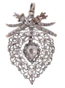 An Iberian style pendant, the silver pierced heart shaped panel with a surmount of an entwined bow,