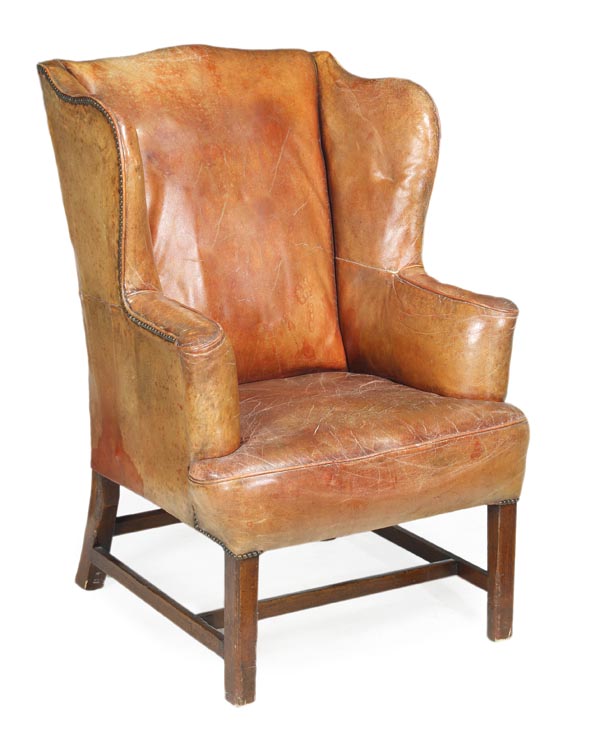 A George III mahogany and studded leather upholstered wing armchair, circa 1815, padded back, arms