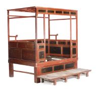 A Chinese red lacquered bed frame, late 18th/19th century, latticed canopy, chamfered supports, the