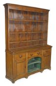 An oak dresser, first quarter 19th century, moulded cornice, arrangement of three open shelves,