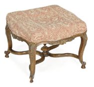 A French carved, stained walnut, parcel gilt and upholstered stool, in Regence style, early 20th