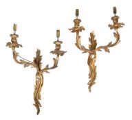 A pair of gilt metal twin light wall appliques, in Louis XV style, early 20th century, of typical