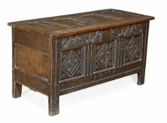 A Charles II carved oak coffer, circa 1660, hinged four panelled top opening to a candle box,