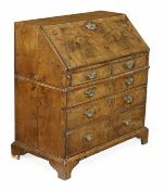 A George II walnut and featherbanded bureau, circa 1740, sloping fall, two short and three long