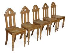 A set of five Victorian oak hall chairs, circa 1870, arched pierced backs, solid seat, turned front