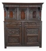 An oak press cupboard, late 17th/early 18th century, the moulded cornice above the acanthus carved