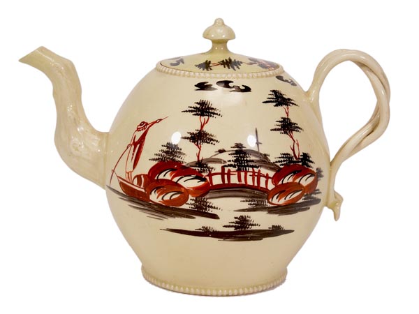 An English creamware globular teapot and cover, probably Derbyshire, Cockpit Hill, painted in iron