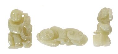 Three Chinese celadon jade carvings in the form of boys holding lingzhi fungi, a chilong beside