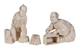 A Japanese ivory okimono of a carpenter, sitting beside a box whilst making and adjusting the blade