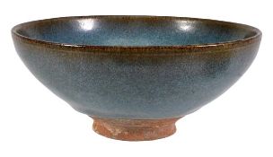 A Jun style bowl of rounded conical form resting on a short cylindrical foot, the whole covered in