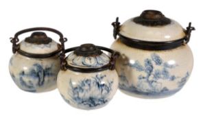 Three Chinese blue and white opium pipes decorated with landscape designs, with metal binding and