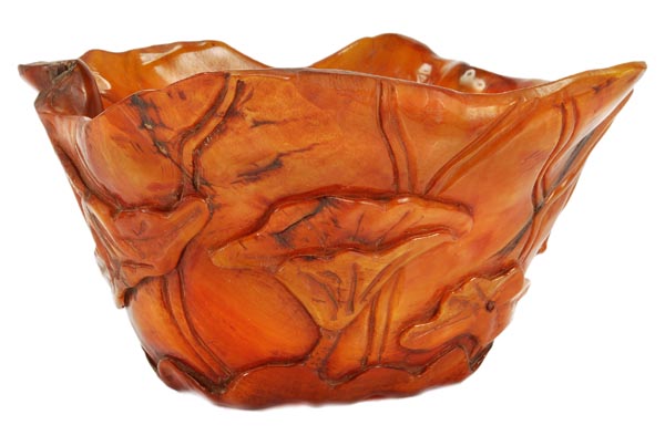 A Chinese buffalo horn libation cup, the vessel moulded and carved to the exterior with lotus