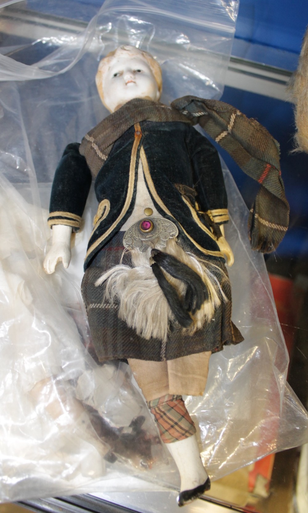 A 19th century bisque shoulder-head doll, with moulded blonde hair and painted facial features, on a