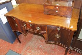 A Georgian style mahogany sideboard of serpentine outline, on tapering block legs, spade feet