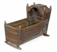 An oak child`s crib, first half 18th century, turned finials, panelled sides, 71cm high, 99cm