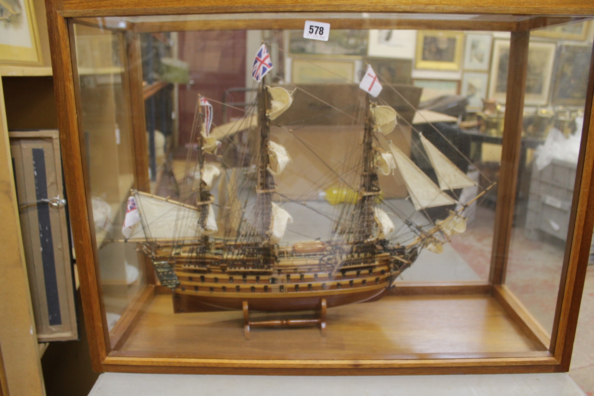 A contemporary scale wooden model of HMS Victory in a glazed case