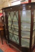 An Edwardian mahogany glazed display cabinet, the central door flanked by serpentine glass on
