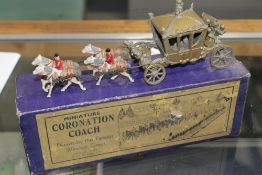 A John Hill & Co. Miniature Coronation Coach, gold, pulled by a team of four Windsor Grey horses,