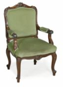 A French walnut and upholstered fauteuil, in Louis XV style, early 20th century, with rocaille