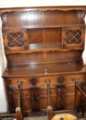 An oak dining table and set of twelve ladderback chairs and a dresser