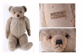 A Merrythought gold mohair teddy bear, circa 1930s, with orange glass eyes and a black vertically