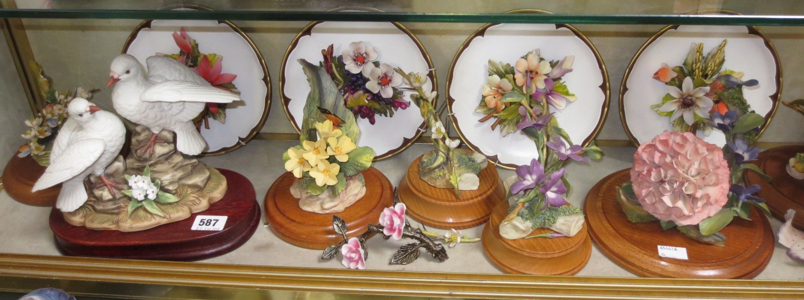 A quantity of Capodimonte botanical models on wooden plinths and four similar plates, together