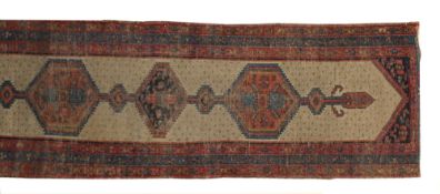 A Serapi runner, the camel ground with a triple pole medallion, within a triple border, worn 106cm x