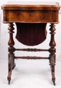 A Victorian walnut games and work table with hinged top, fitted a needlework drawer with remnant