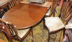 A mahogany Regency style dining table and six shield back chairs and one additional leaf.