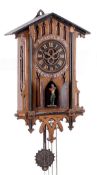 A German Black Forest carved oak weight-driven four horn ÔtrumpeterÕ wall clock Attributed to