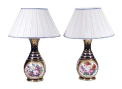 A pair of Continental porcelain table lamps, 20th century, painted floral reserves on a blue