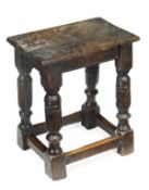A Charles II oak joint stool, circa 1660, plank top, turned legs and rectangular stretchers, 49cm