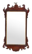 A George II mahogany and parcel-gilt mirror, circa 1750, the later oblong plate in a cut and shaped