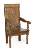 An oak panel back armchair, circa 1660 and later, rectangular back carved with flowering foliage