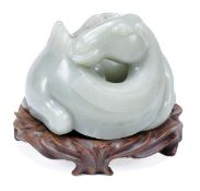 A Chinese jade figure of a reclining Bactrian camel, the animal curled into an annular form with