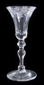 An engraved light baluster wine glass, the bell bowl decorated with a band of fruiting vine,