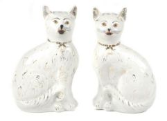 A pair of Scottish pottery cats modelled, facing left and right, sparsely coloured and gilt, height