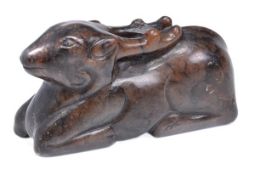 A Chinese brown jade carving of a reclining deer, the head looking forwards, the horns extending