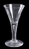 A plain-stemmed wine glass, drawn trumpet form with tear inclusion, on a conical foot, 18cm high,