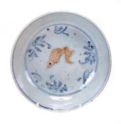 A Chinese blue and white bowl decorated with a biscuit fish swimming amid stylised aquatic plants,