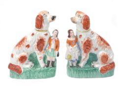 A pair of Staffordshire models of Afghan hounds with small children, modelled facing left to right,