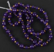 A two row amethyst bead necklet, the facetted beads alternating with pairs of smaller round beads,