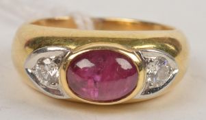 A French ruby and diamond ring, the cabochon ruby flanked on both sides by single round brilliant