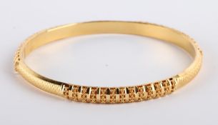 * An Indian bangle, stamped `22K`, of hollow D section, with diamond cut decoration,5.5cm internal