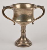 A silver trophy cup by Turner & Simpson, London 1934, with twin leaf capped scroll handles, a