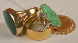 Three rings and a South African coin pendant, the carved oval jadeite claw set above a plain shank,